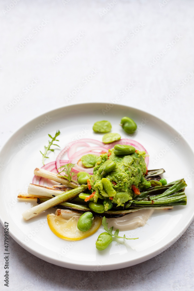 Grilled spring onions with tahini sauce, broad beans salasa and pickled onions Grilled spring onions with tahini sauce, broad beans salasa and pickled onions