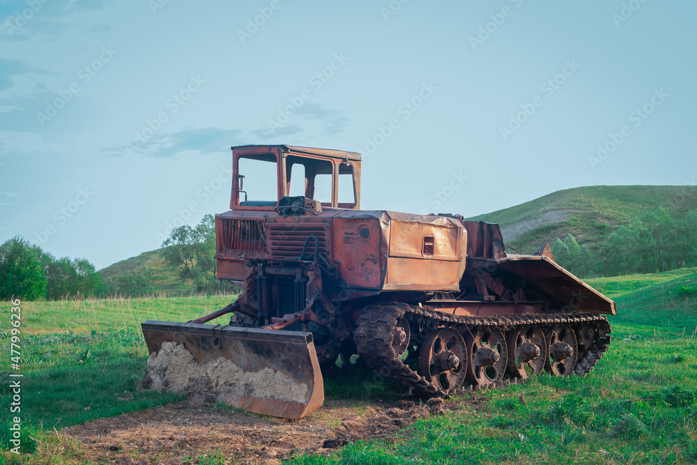 Agricultural machinery in the meadow. Farming machinery for cultivating the land. Old tractor.