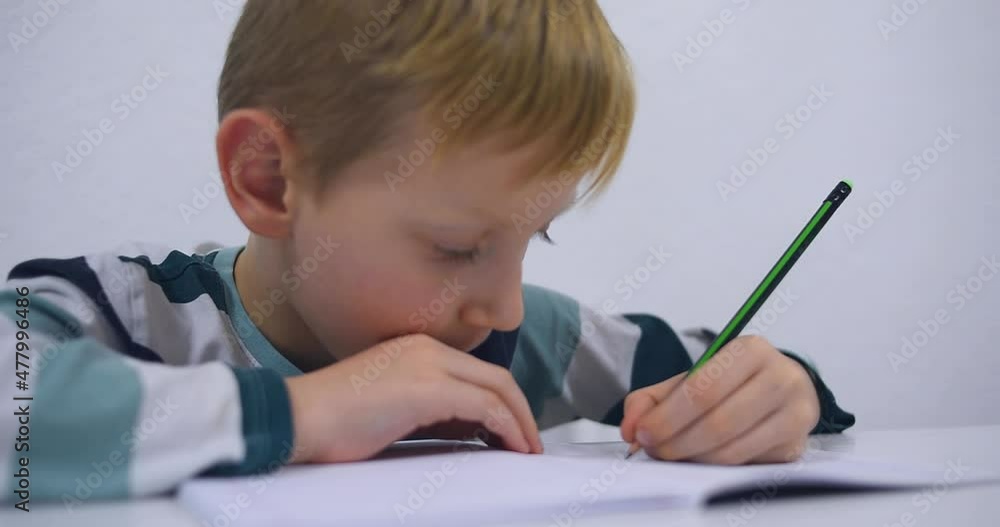 School boy practicing writing the alphabet at home. Boy child kid writing. Homework. School boy practicing writing the alphabet at home. Boy child kid writing. Homework.