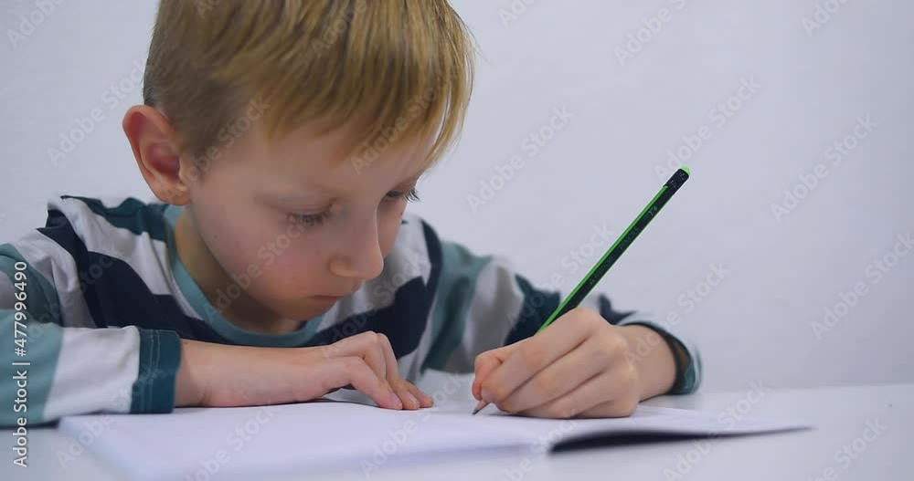 School boy practicing writing the alphabet at home. Boy child kid writing. Homework. School boy practicing writing the alphabet at home. Boy child kid writing. Homework.