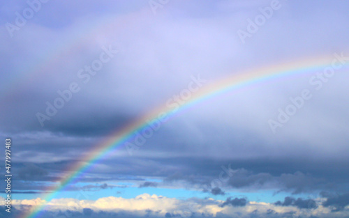 Natural two rainbows over the sea, rainy weather and sun