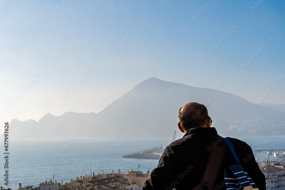 Unrecognizable man from behind observing the landscape on a sunny morning