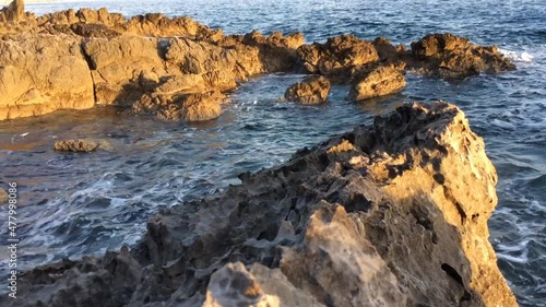 The sea waves beat against the shore rocks
