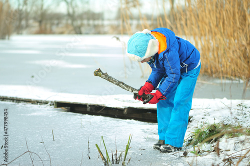 A child in danger on thin ice in winter. The boy is ice skating on a frozen lake.