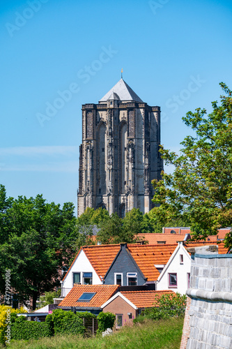 Fototapeta Naklejka Na Ścianę i Meble -  Walking in old Dutch town Zierikzee with old church tower, small houses and streets