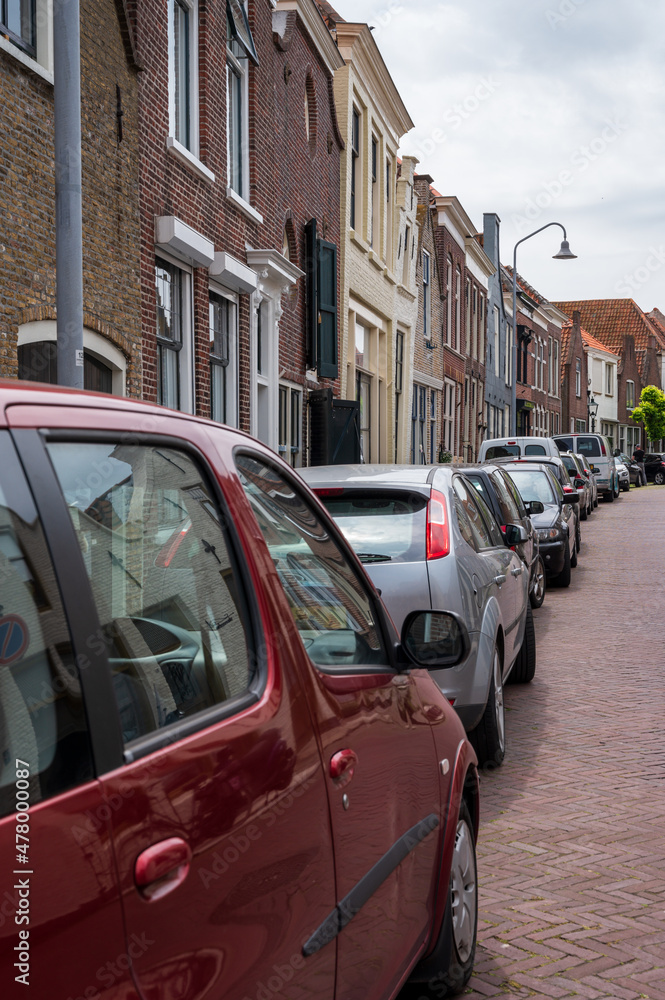 Street parking of cars in old Dutch town Zierikzee with old small houses and streets