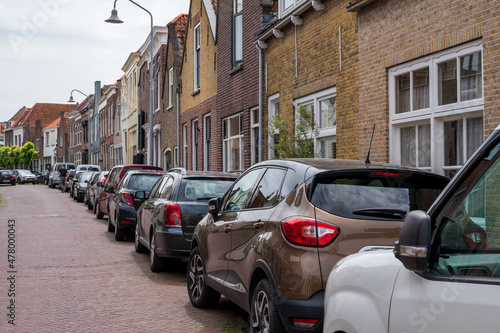 Street parking of cars in old Dutch town Zierikzee with old small houses and streets © barmalini