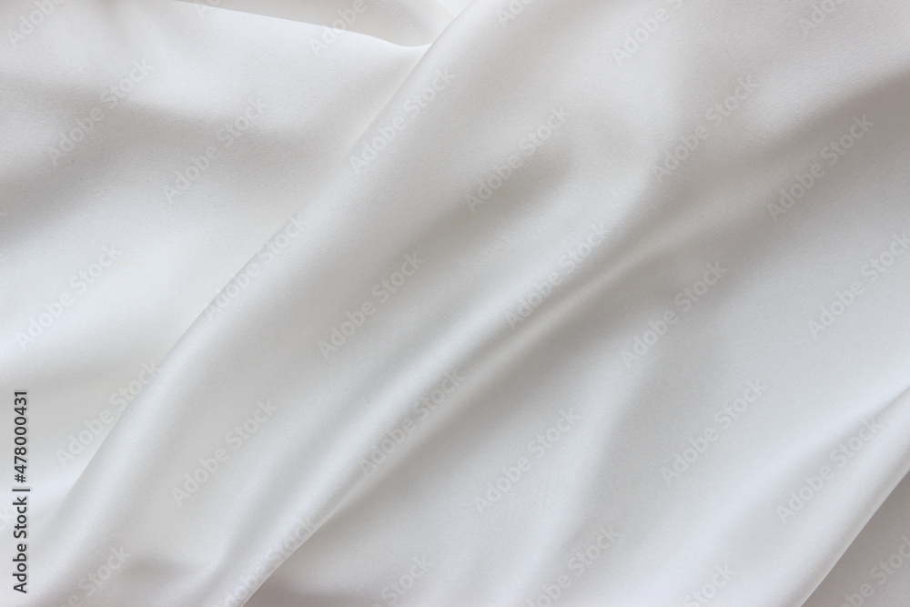White silk fabric background. Abstract smooth elegant texture for design. Flowing satin waves.