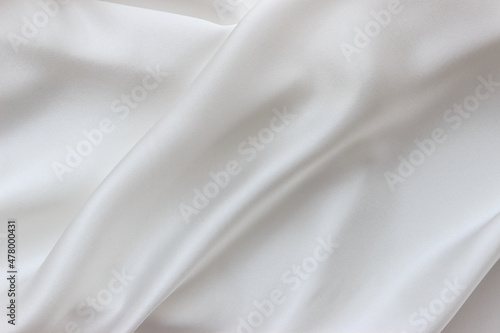 White silk fabric background. Abstract smooth elegant texture for design. Flowing satin waves.