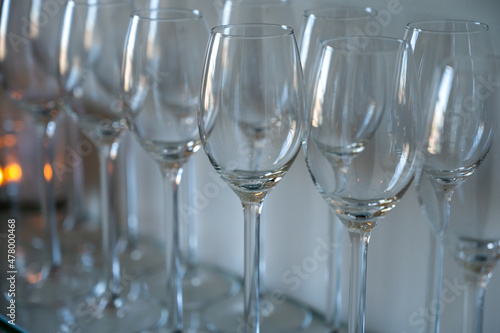 Many empty clean wine glasses on shelf in restaurant