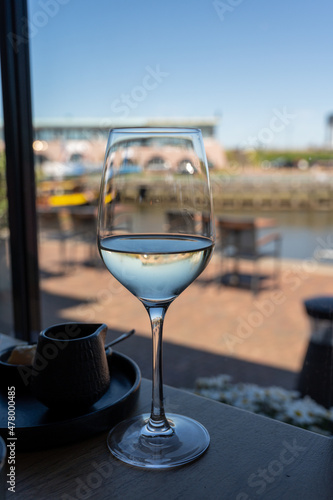 Glass of white wine served in cafe with view on harbour of Harlingen  vacation in Friesland  Netherlands
