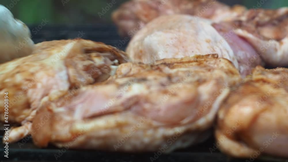 with tongs, he turns the chicken thighs on the grill. focus on the middle of the grid. they acquire a toasted color with tongs, he turns the chicken thighs on the grill. focus on the middle of the grid. they acquire a toasted color