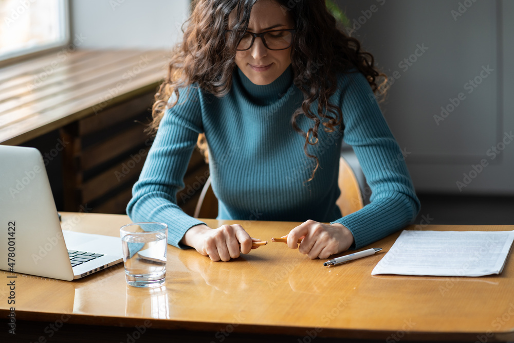 Anxiety at work. Young stressed female employee with broken pencil sitting in front of laptop at workplace, worried frustrated businesswoman feeling nervous, having job burnout. Selective focus Anxiety at work. Young stressed female employee with broken pencil sitting in front of laptop at workplace, worried frustrated businesswoman feeling nervous, having job burnout. Selective focus
