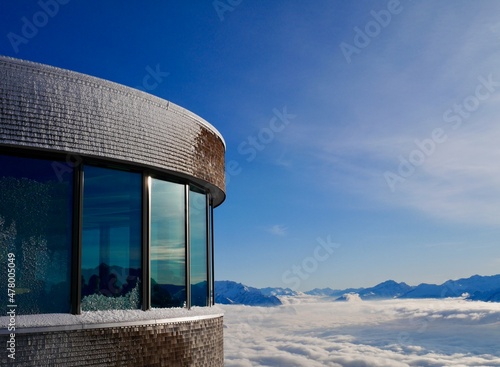 Modern mountain restaurant with glass front at mountain station of Hoher Kasten cable car with spectacular view of Austrian Alps in winter. Alpstein, Appenzell, Switzerland. photo