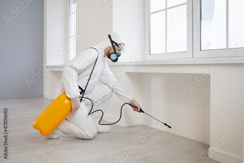 Foto Pest control exterminator getting rid of insects inside infested house