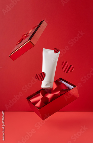 Εκτύπωση καμβά White bottle cosmetic product in red giftbox levitate on red background