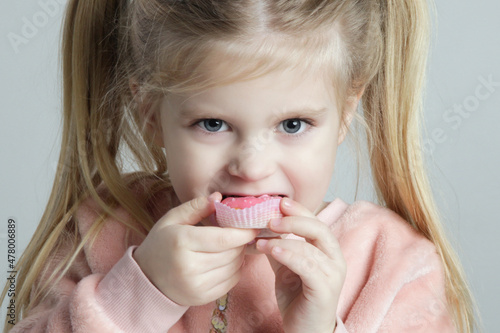 Close up portrait of adorable little girl eating donut