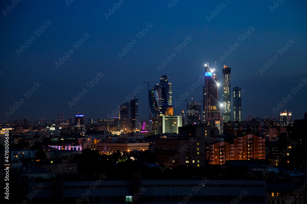 Evening (night) illuminated towers of Moscow City. Buildings construction on deep blue sky. Panoramic photo. Evening (night) illuminated towers of Moscow City. Buildings construction on deep blue sky. Panoramic photo.