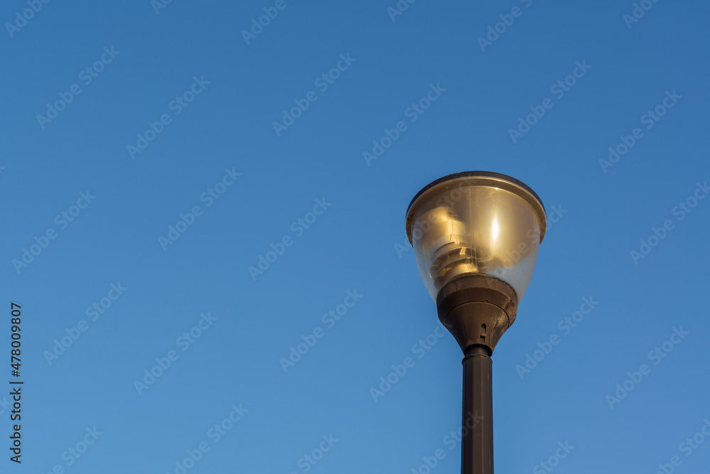Street lantern, electric lighting. Lamp on background of blue sky.