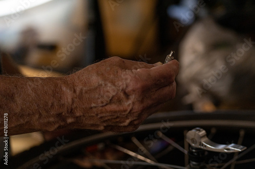 Closeup of white man's hand with small piece of bike tire during repair