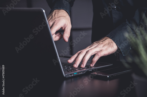 Businessman using a smartphone and notebook in a moddy office photo