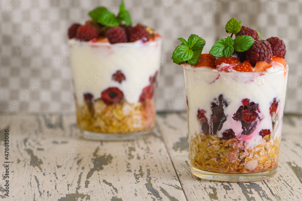 Natural Greek yogurt with fresh berries and muesli in a glass. Healthy food, healthy lifestyle Natural Greek yogurt with fresh berries and muesli in a glass. Healthy food, healthy lifestyle