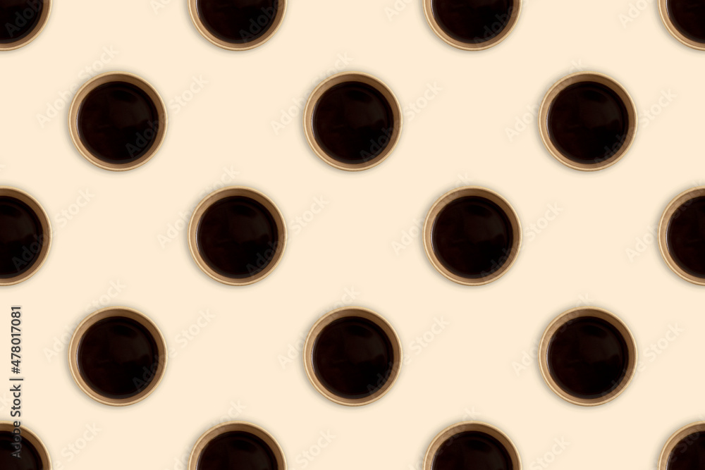 Black coffee in disposable paper cups on beige background. Top view. Seamless repeating pattern.