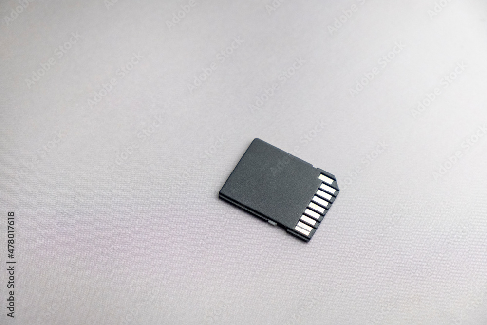 black micro sd card with gold contacts on a gray background black micro sd card with gold contacts on a gray background