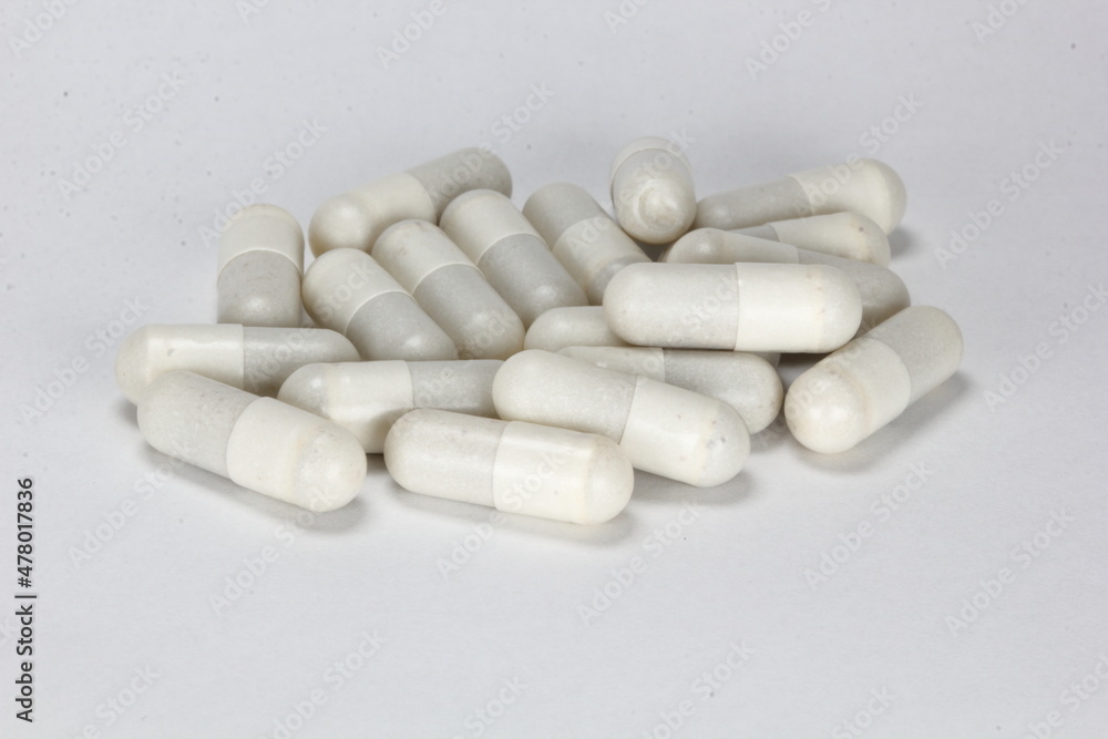 White medicine capsules, pills, tablets on white background	