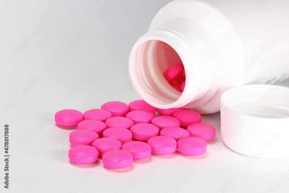 Pink medicine tablet antibiotic pills spilling out of a bottle Pink medicine tablet antibiotic pills spilling out of a bottle