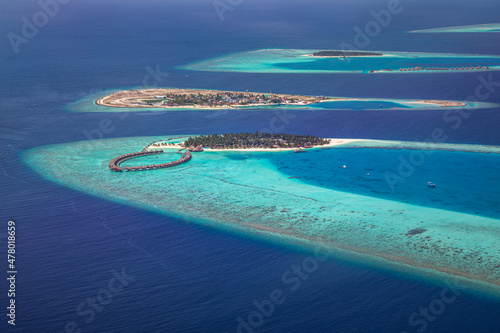 Aerial photo of beautiful Maldives paradise tropical beach. Amazing view, blue turquoise lagoon water, palm trees and white sandy beach. Luxury travel vacation destination. Sunny aerial landscape 