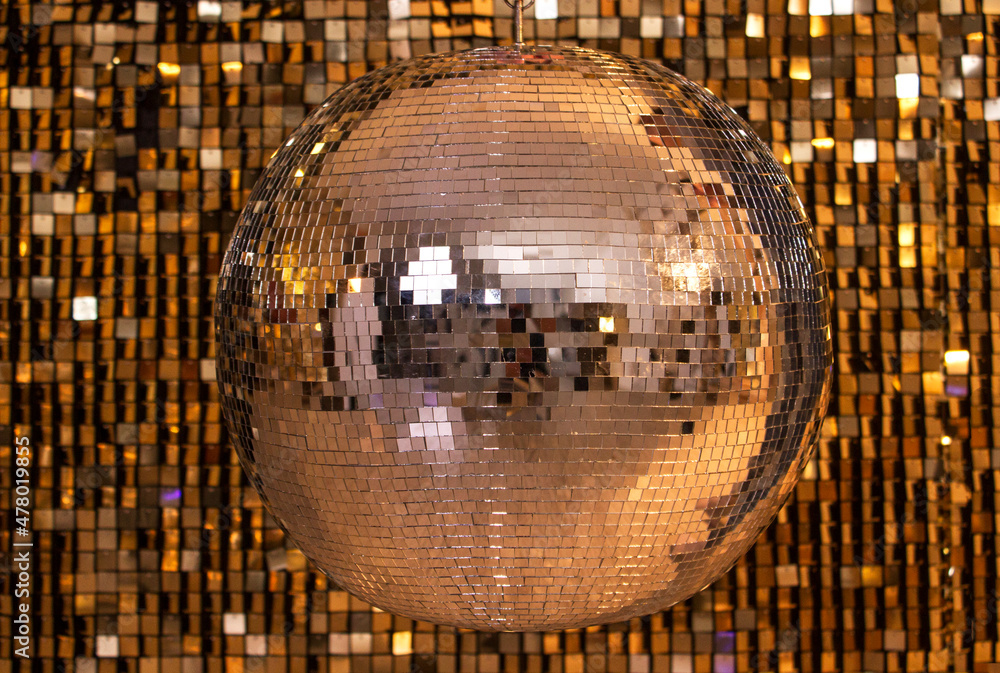 silver disco ball on a wall of sequins Stock Photo Adobe Stock