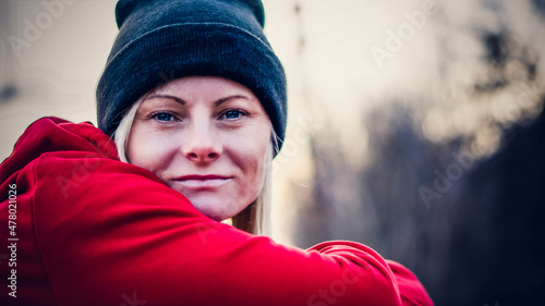 Zimowy portret kobiety w czapce i czerwonej bluzie photo
