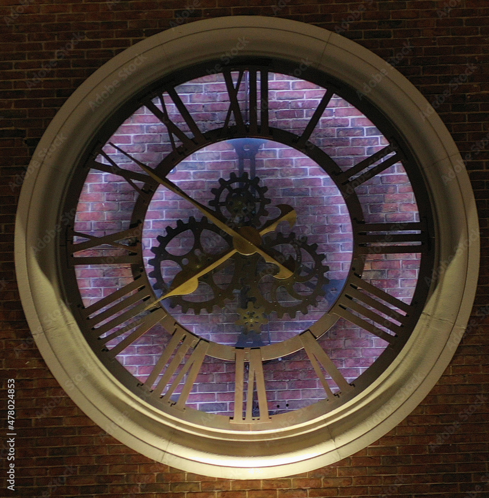 facade round clock with backlight on the brick wall of the building 