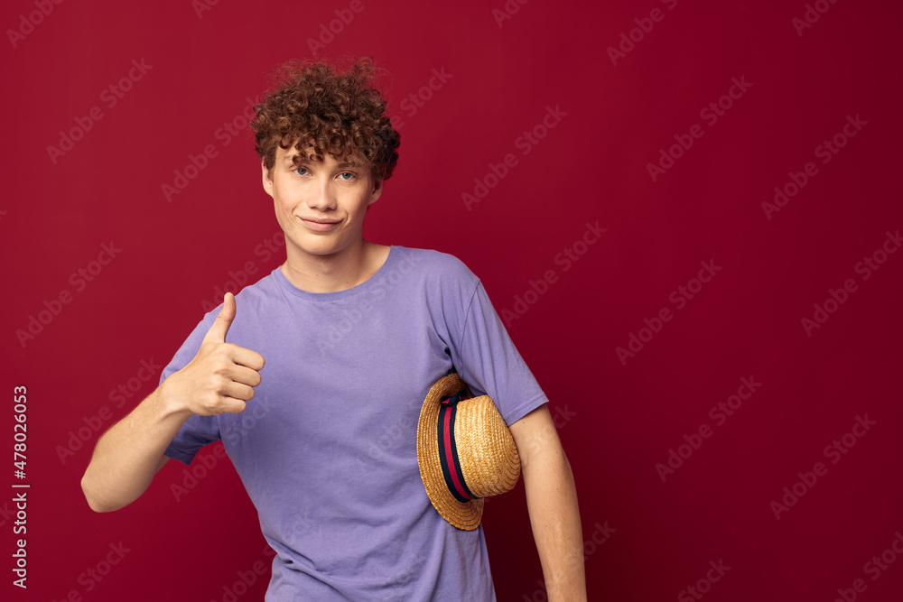 A young man fashion posing hand gestures stylish hat red background unaltered