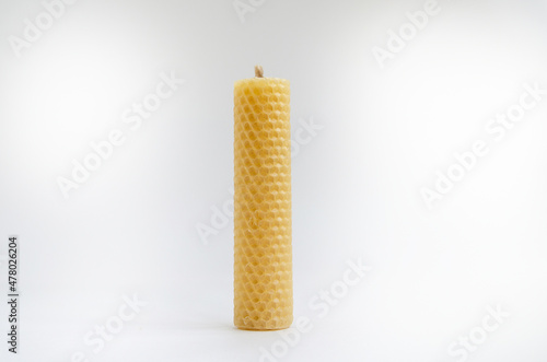 Yellow round wax candles with a honeycomb pattern on a white background