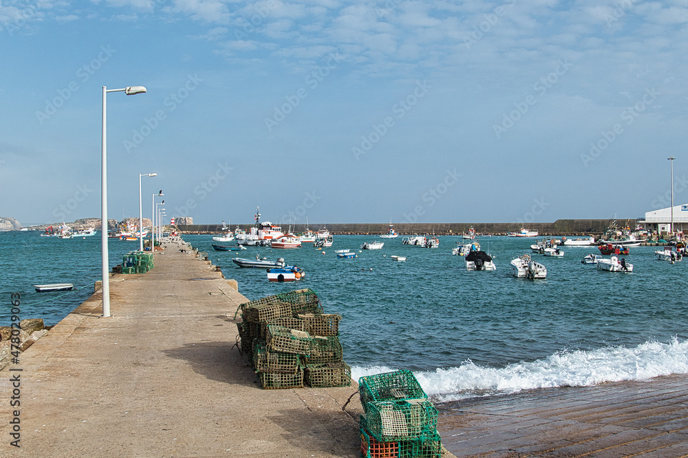 The fishing harbour of Sagres, Algarve, Portugal, with a long pier and protected by a huge sea wall. Lobster pots in de foreground

