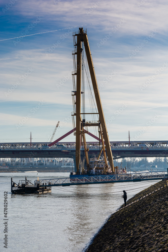 A fisherman on the banks of the Danube, against the background of the Rákóczi bridge in Budapest.