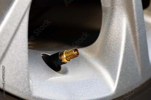 Tire valve stem on car wheel. Vehicle safety, tire wear, fuel mileage and winter checkup concept.  photo