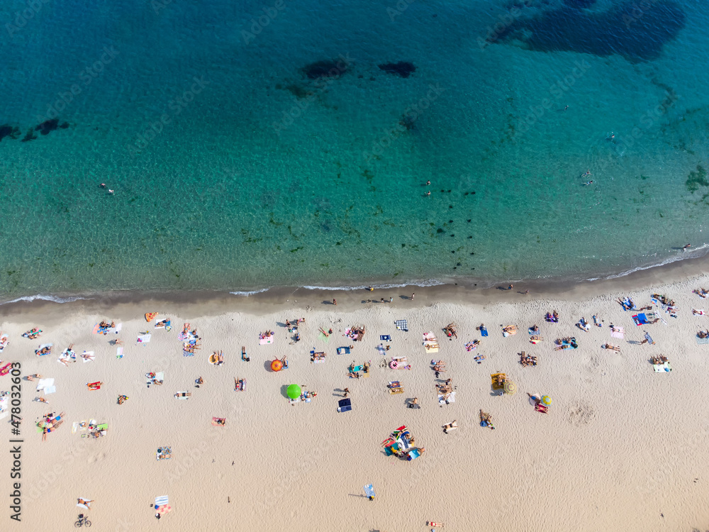 The beach is filled with vacationers by the sea. Top view from drone. The beach is filled with vacationers by the sea. Top view from drone.