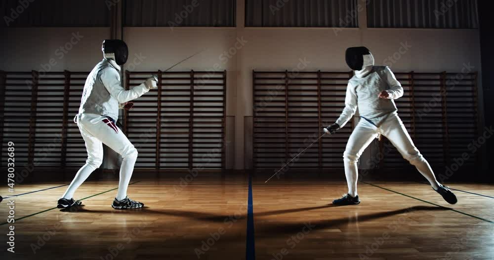 Two Men In Fencing Gear Duelling With Foils Two Men In Fencing Gear Duelling With Foils