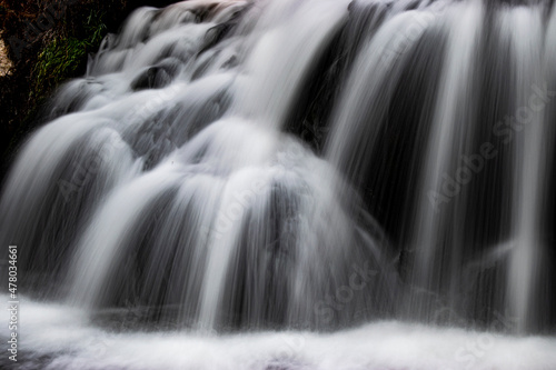 white stream waterfall flowing in dark green forests at night long exposure