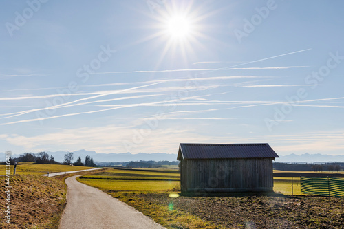 View to the mountains at a small road in bright sunshine and blue sky in the Ammergau Alps photo