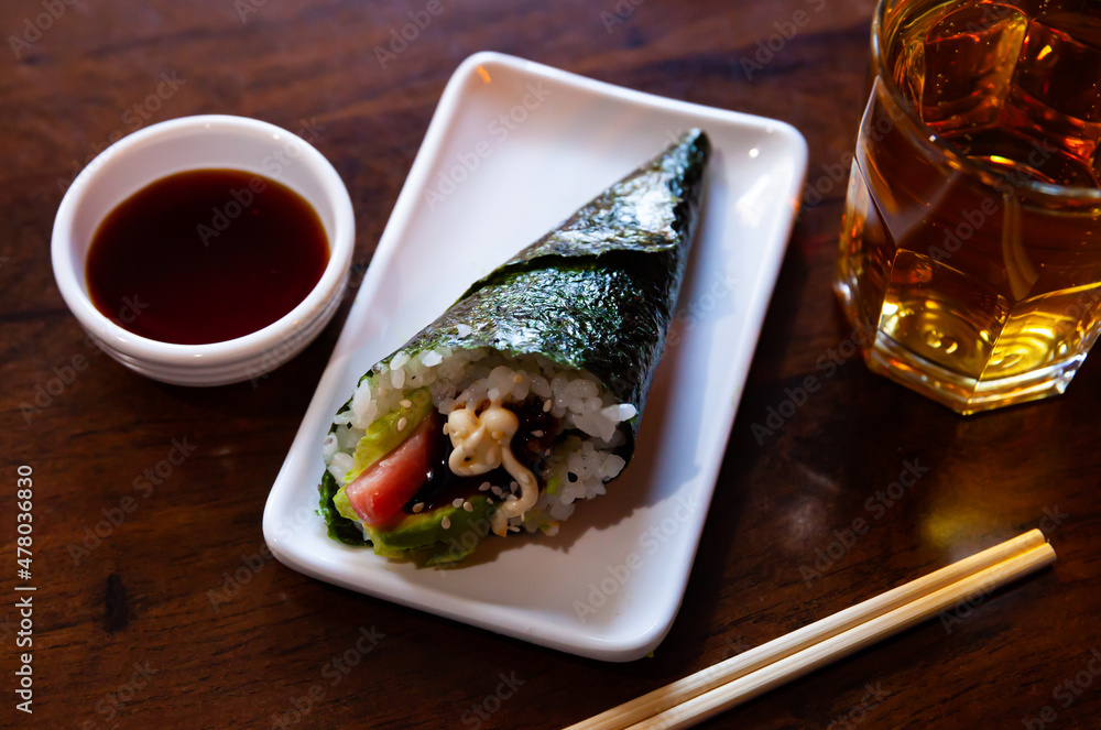 Delicious temaki sushi with tuna and avocado tossed with mayonnaise. Popular Japanese hand roll