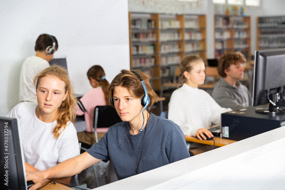 Obraz premium Teenage student in headphones at the computer in a school class