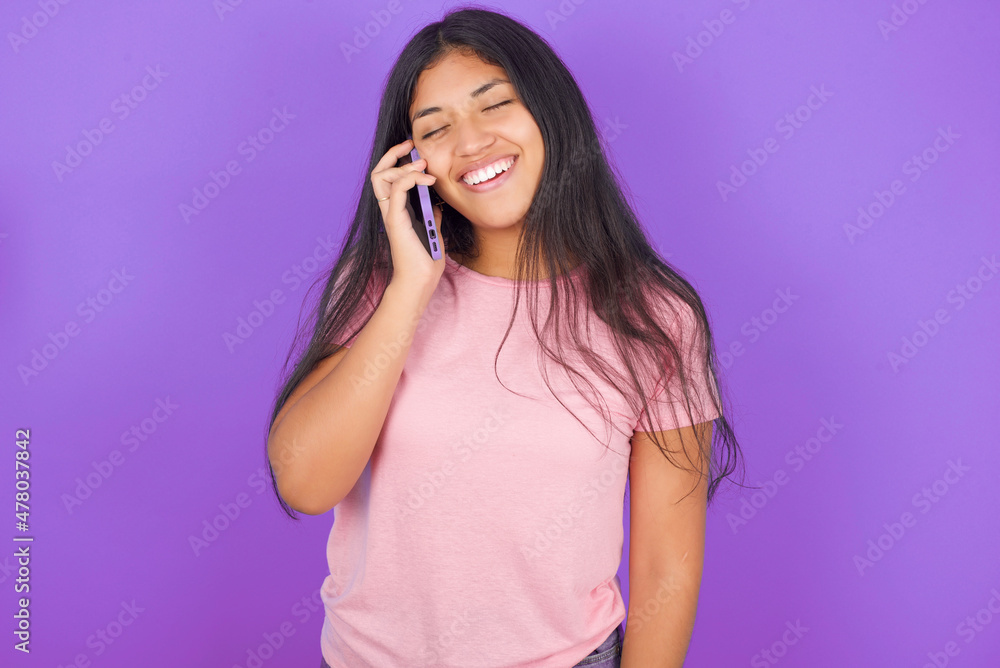 Funny MODEL laughs happily, has phone conversation, being amused by friend, closes eyes. Funny MODEL laughs happily, has phone conversation, being amused by friend, closes eyes.