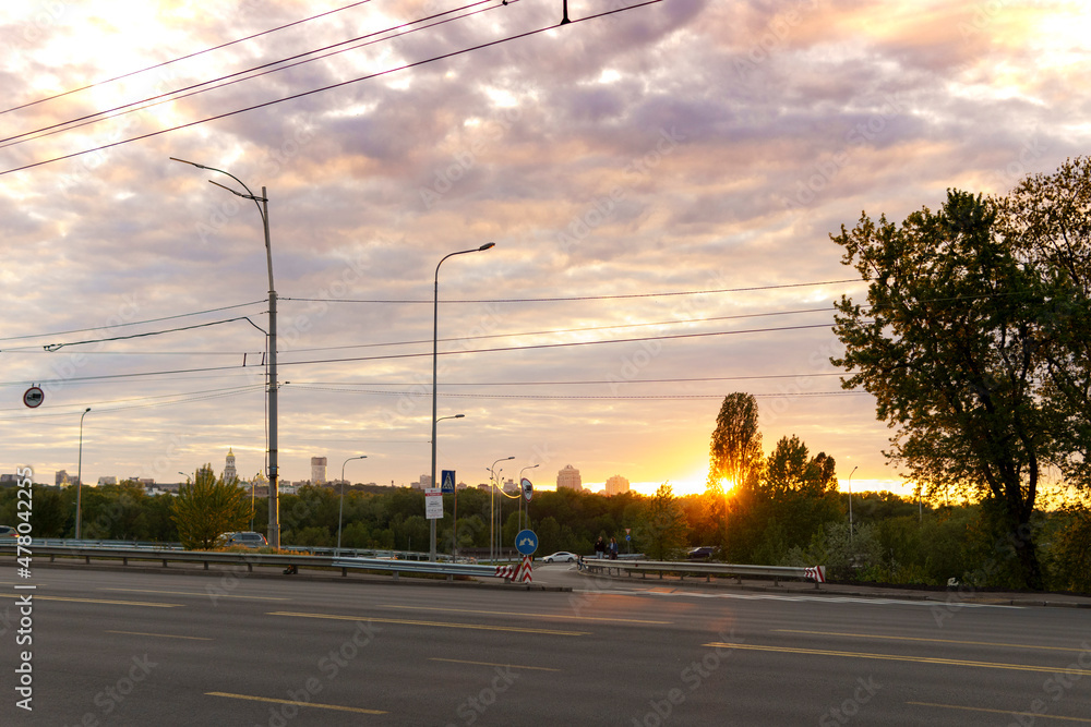 summer, heat, travel, weather, cityscape - background wide paved roadway road with city cars in spring hot evening at sunset, summertime sunrise grey cloudy sky
