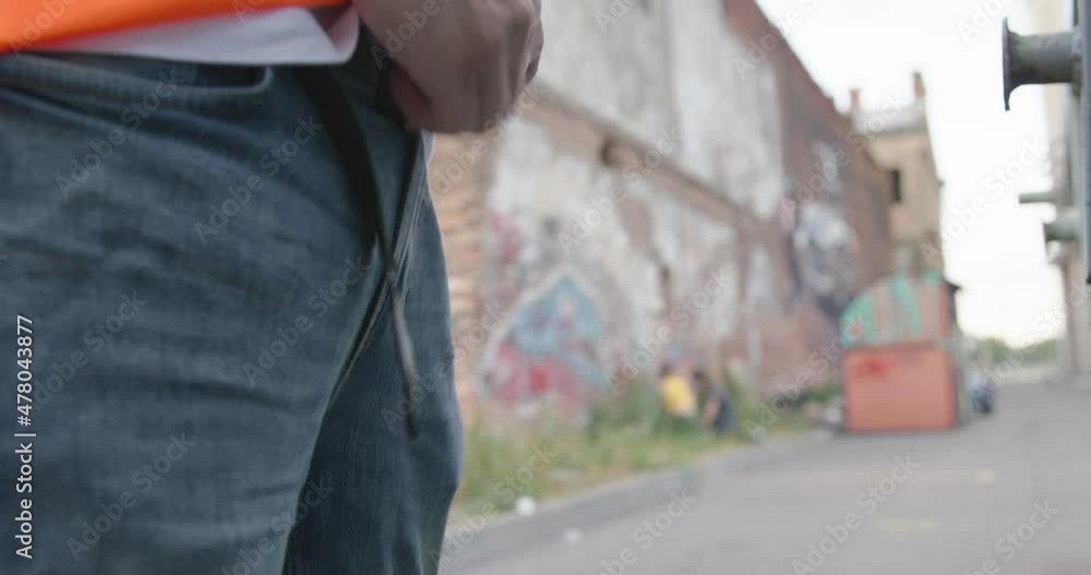 Vandal zips up the fly on jeans after peeing on the street in broad daylight, forgetting to fasten leather belt, then put his hands in pockets as if nothing had happened, close up. Vandal zips up the fly on jeans after peeing on the street in broad daylight, forgetting to fasten leather belt, then put his hands in pockets as if nothing had happened, close up.