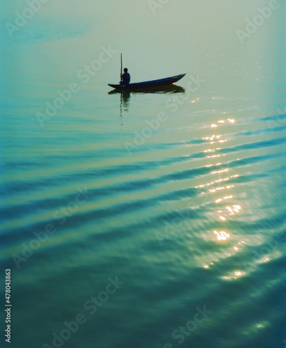 Fotografie, Obraz Silhouette of Vietnamese fisherman in traditional sampan fishing boat