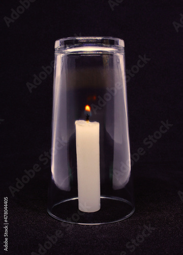 Science experiment: candle going out due to low oxygen in the glass photo